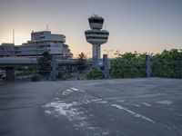 some cars are parked at an air traffic control tower with smoke coming from the air