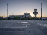some cars are parked at an air traffic control tower with smoke coming from the air