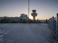 some cars are parked at an air traffic control tower with smoke coming from the air