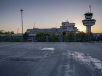 some cars are parked at an air traffic control tower with smoke coming from the air