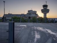 some cars are parked at an air traffic control tower with smoke coming from the air