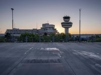 some cars are parked at an air traffic control tower with smoke coming from the air