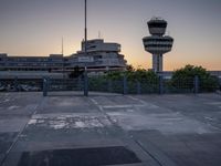 some cars are parked at an air traffic control tower with smoke coming from the air
