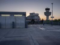 some cars are parked at an air traffic control tower with smoke coming from the air
