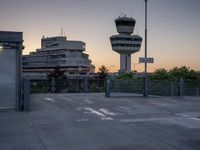 some cars are parked at an air traffic control tower with smoke coming from the air