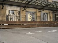 an empty building with signs on the street and people on bikes in traffic passing by