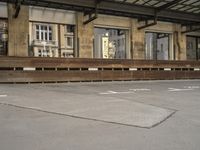 an empty building with signs on the street and people on bikes in traffic passing by