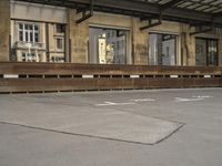 an empty building with signs on the street and people on bikes in traffic passing by