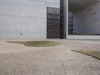 the large concrete structure has several windows and doors around it with small grass on top