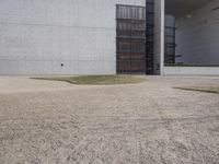 the large concrete structure has several windows and doors around it with small grass on top