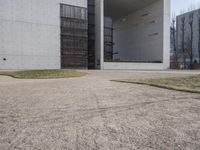 the large concrete structure has several windows and doors around it with small grass on top