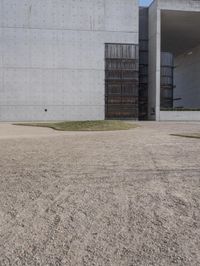 the large concrete structure has several windows and doors around it with small grass on top