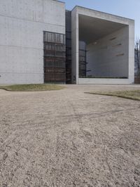 the large concrete structure has several windows and doors around it with small grass on top