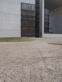 the large concrete structure has several windows and doors around it with small grass on top