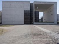 the large concrete structure has several windows and doors around it with small grass on top