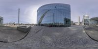 a large modern building and many parking spaces in front of it as seen through fisheye