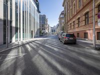 an intersection with vehicles on the road, buildings and street signs on a sunny day