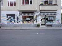 the outside of a book shop has graffitti on the wall and windows in it