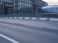 a road with an umbrella near a bridge and large buildings on both sides of the street