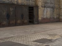 a black fire hydrant and brick wall and door area with one open one close