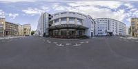 a fish eye photo of a large white building with multiple windows and a street sign