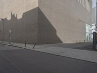 a large beige building next to a tall brick building on the street as if in another country, it is sunny