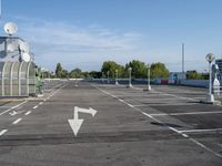 an empty parking lot with satellite antennae on top and arrow pointing to the left behind