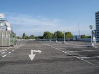 an empty parking lot with satellite antennae on top and arrow pointing to the left behind