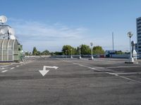 an empty parking lot with satellite antennae on top and arrow pointing to the left behind