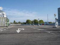 an empty parking lot with satellite antennae on top and arrow pointing to the left behind