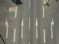 an aerial shot of an empty road, with a red traffic light on each side