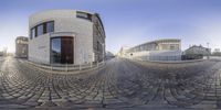 this circular photo shows an outside area of a building with stone paving on both sides