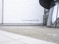 a white building with an interesting, geometric entrance mat in front of it's door