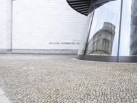 a white building with an interesting, geometric entrance mat in front of it's door