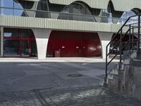 the steps lead from the ground to a building with red doors in front of it