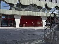 the steps lead from the ground to a building with red doors in front of it