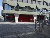 the steps lead from the ground to a building with red doors in front of it