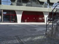 the steps lead from the ground to a building with red doors in front of it