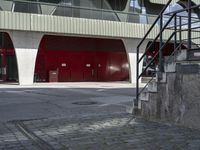 the steps lead from the ground to a building with red doors in front of it