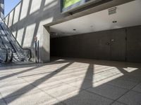 escalator walkway with a tile and glass walkway in between two buildings with stairs and large windows