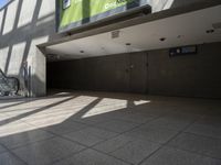 escalator walkway with a tile and glass walkway in between two buildings with stairs and large windows