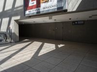 escalator walkway with a tile and glass walkway in between two buildings with stairs and large windows