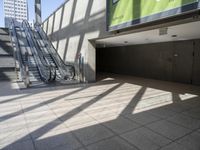 escalator walkway with a tile and glass walkway in between two buildings with stairs and large windows