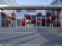 a large red building with multiple glass panels on the front doors and outside of them