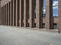 there are many windows that line a building and on the sidewalk, along with other red brick buildings