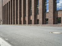 there are many windows that line a building and on the sidewalk, along with other red brick buildings