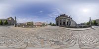 an old fashioned building is surrounded by cobblestone in the city area of a wide angle