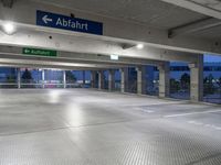 there is an empty parking garage with a sign in the ceiling above it and on the right corner, a bright light shines in the ground