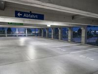 there is an empty parking garage with a sign in the ceiling above it and on the right corner, a bright light shines in the ground