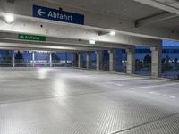 there is an empty parking garage with a sign in the ceiling above it and on the right corner, a bright light shines in the ground